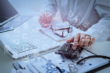 Healthcare costs and fees concept.Hand of smart doctor used a calculator for medical costs in modern hospital