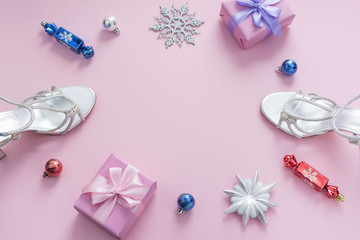 Decorative background pink Christmas composition Flat lay box gift ribbon bow snowflake sandals silver Christmas tree toys.