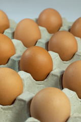 eggs in carton box . close up brown fresh many chicken eggs in packaging .