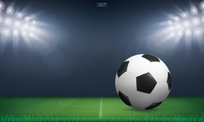 Naklejka premium Soccer football ball on green grass of soccer field or football field stadium background. Vector.