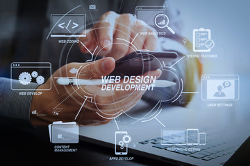 close up of businessman working with mobile phone and stylus pen and laptop computer on wooden desk...