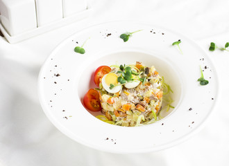 Russian Olivier salad with meat, quail eggs and cherry tomatoes