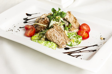 Warm salad with meat, mushrooms, cherry tomatoes, pine nuts and herbs