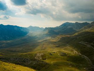 Fototapeta premium View on a valley in Durmitor national park, Montenegro, in cloudy day with sunlight shining through the sky