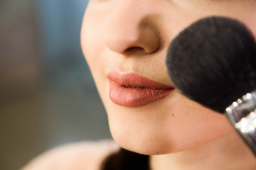 Beauty and health clean Skin of young female Model. Woman applying Powder Foundation with Brush.