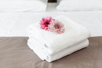 Obraz na płótnie Canvas towels and flower on bed in hotel room