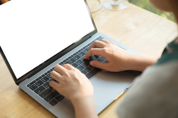 Fototapeta premium Women using laptop with blank screen at table in the office.