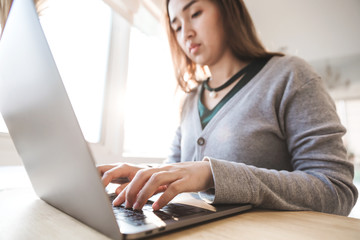 Women using laptop with blank screen at table in the office.