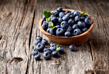blueberries in bowl  on  wooden background