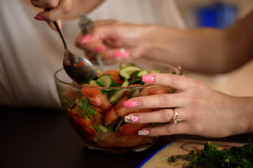 Young sisters making vegetable salad at home