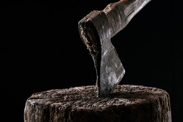  close up view of vintage axe on wooden stump isolated on black