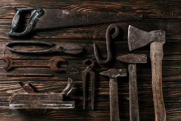 flat lay with assortment of vintage rusty carpentry tools on wooden surface