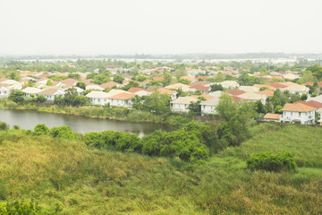 Fototapeta na wymiar The housing estate village near nature zone. Trees and canal.