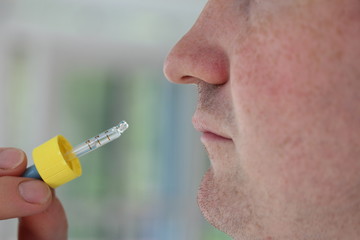 A man putting a nasal spray in nose.
