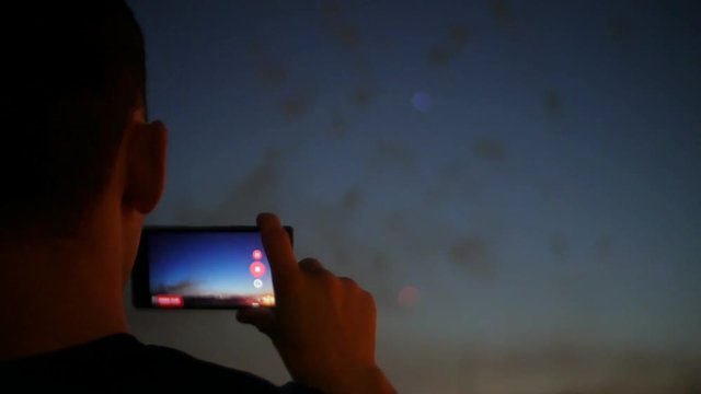spectators with smartphones. Photograph firework on the phone, close-up hands