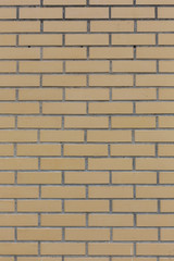 Yellow with grey seams stone bricks wall pattern texture background vertical shot