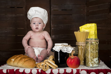 little boy in the cook's cap on the background of the products