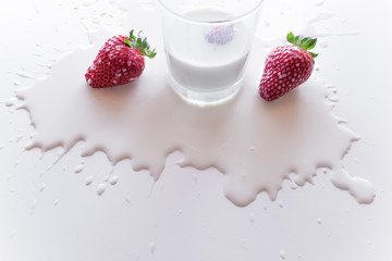 Erdbeeren über ausgekippter Milchpfütze