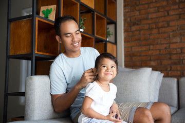 asian father brush daughter hair
