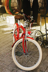 Fototapeta na wymiar Retro red bicycle, for sale on the sidewalk of the city