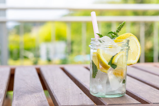 Frische selbstgemachte Zitronenlimonade auf einem Holztisch im Garten 