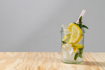 Frische limonade mit frischen Zitronen und Eiswürfeln in einem Glas mit Strohhalm
