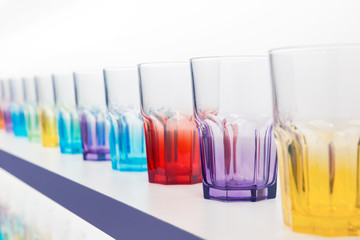 Many empty coloured Glasses  in a row on a bar