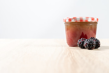 Glass of berry jelly on a wooden table 