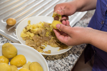 Person schält frisch gekochte Kartoffeln