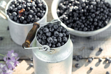 Fresh blueberry in old rustic dish, wooden background, selective focus.