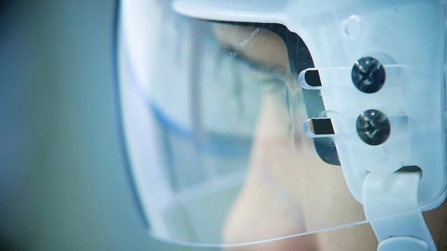 slow motion hockey player glance from behind glass protector