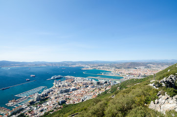 Fototapeta na wymiar Overall view from top of the Rock of Gibraltar city, cruise port with liner and marina, airport runway, Gibraltar Bay or Bay of Algeciras.