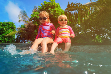 Fototapeta premium happy kids play with water in pool of tropical resort