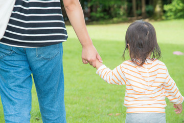 Fototapeta premium 公園で手をつなぐ親子