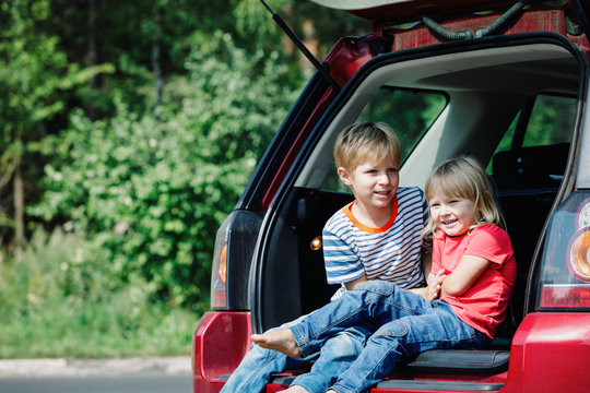 happy little girl and boy travel by car