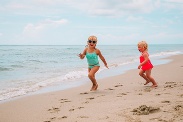 little girls run play have fun at beach