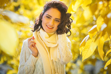 Young beautiful woman at autumn background. Portrait of attractive young girl outdoors