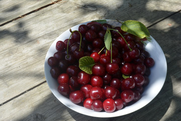 cherry in a plate on a wooden background