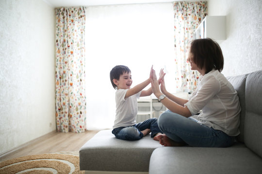 Beautiful Brunette Mom And Son Hugging Sofa