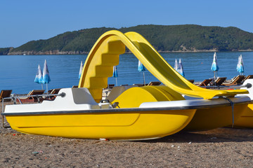 Fototapeta premium Yellow catamaran on the beach. Preparation for the beach season. Entertainment at sea.