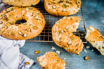 Healthy breakfast concept, home made cereal bagels with milk glass, on blue background copy space