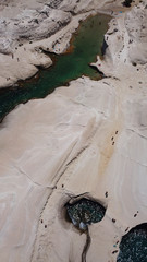 Aerial drone bird's eye view of iconic lunar volcanic white chalk iconic beach and caves of Sarakiniko, Milos island, Cyclades, Greece