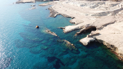 Aerial drone bird's eye view of iconic lunar volcanic white chalk iconic beach and caves of Sarakiniko, Milos island, Cyclades, Greece