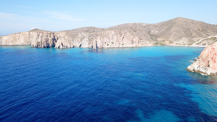 Aerial drone bird's eye view of volcanic and exotic rocky beach with turquoise and sapphire clear waters of Plathiena in island of Milos, Cyclades, Greece