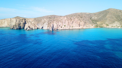 Obraz premium Aerial drone bird's eye view of volcanic and exotic rocky beach with turquoise and sapphire clear waters of Plathiena in island of Milos, Cyclades, Greece