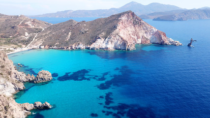 Aerial drone bird's eye view of volcanic and exotic rocky beach with turquoise and sapphire clear...