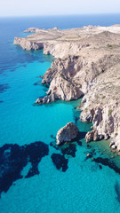 Aerial drone bird's eye view of volcanic and exotic rocky beach with turquoise and sapphire clear waters of Plathiena in island of Milos, Cyclades, Greece
