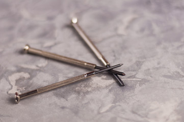 Three new small metal screwdriver on old gray concrete background