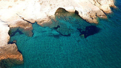 Aerial drone bird's eye view of iconic lunar volcanic white chalk caves and beach of Kapros next to famous caves of Papafragas, Milos island, Cyclades, Greece