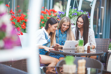 Group of young pretty women making online shopping in the cafe